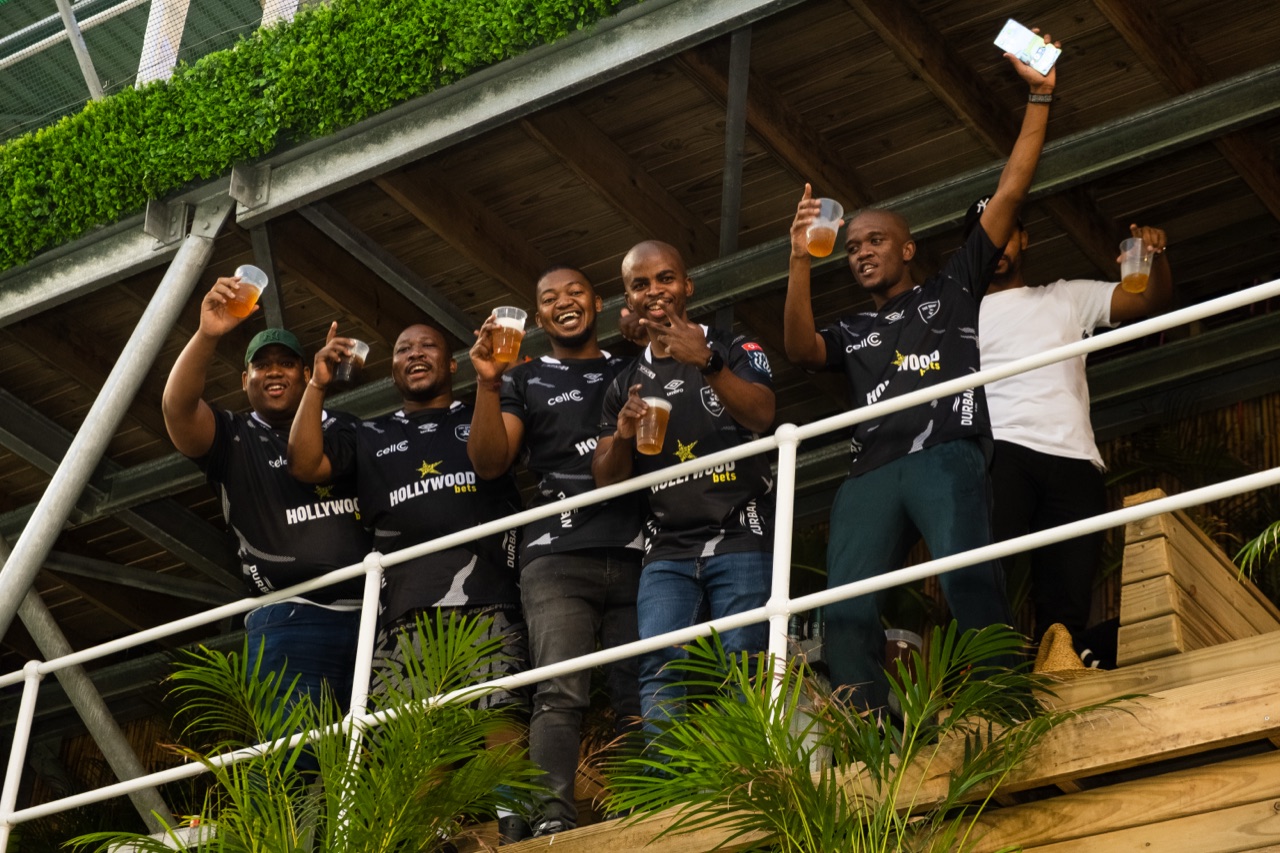 Friends celebrating on the deck with the stadium behind them